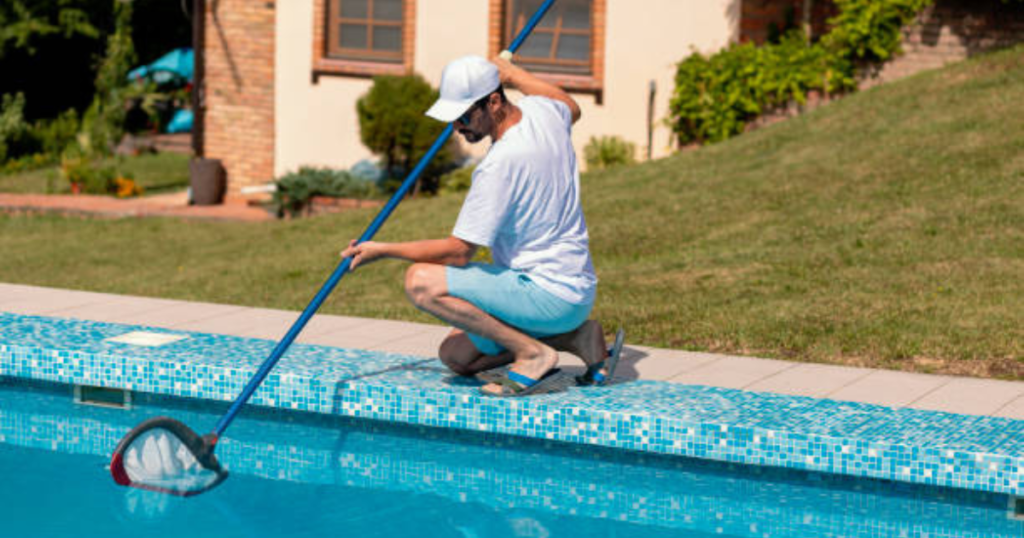 A person cleaning the pool